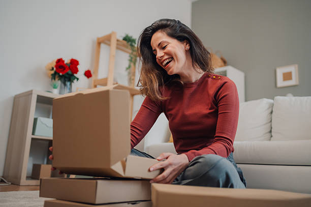 istock Happy woman opening a package at home 2212958666