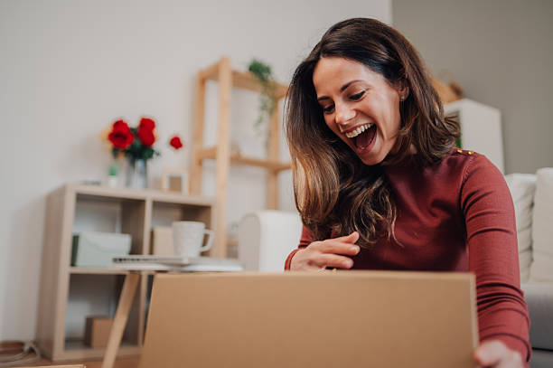 istock Excited woman opening a package at home 2212958667