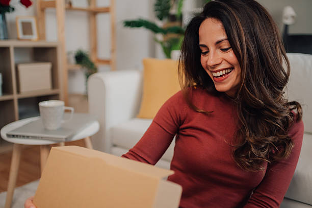 istock Happy woman opening a package at home 2212958677