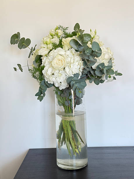 istock natural white flowers,  greenery in a transparent vase 2212960575
