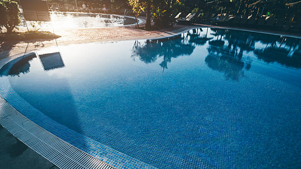 istock Calm resort pool with palm trees 2212960788