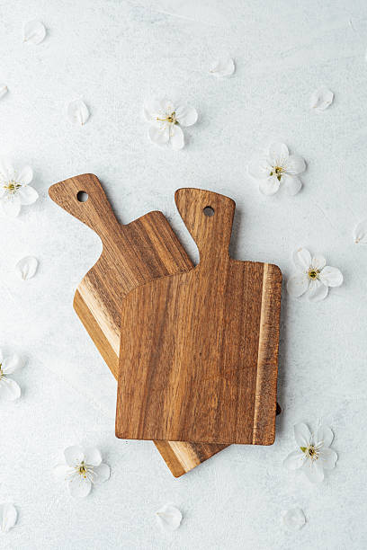 istock Natural wooden cutting boards arranged with decorative flowers on surface 2212966102