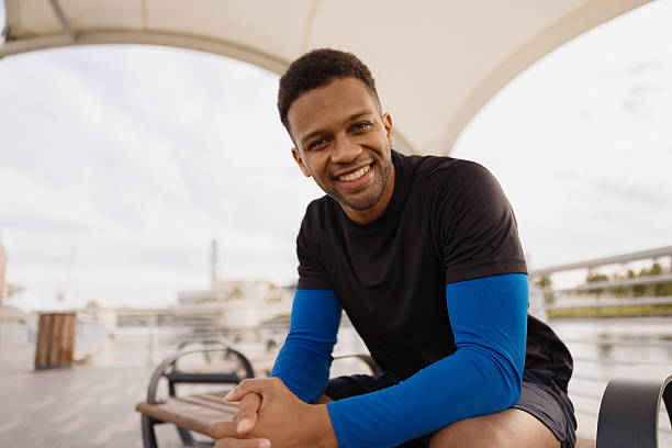 istock Smiling Man Sitting Outdoors Under Canopy at Waterfront 2212966212