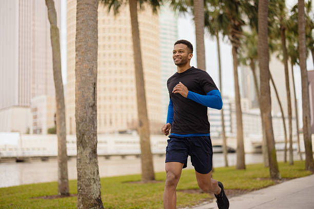 istock Smiling Man Running Outdoors in an Urban Park with Palm Trees 2212966234