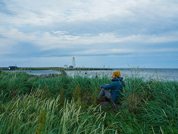 Serene man  looking at scenic lighthouse in Reykjavik, Iceland