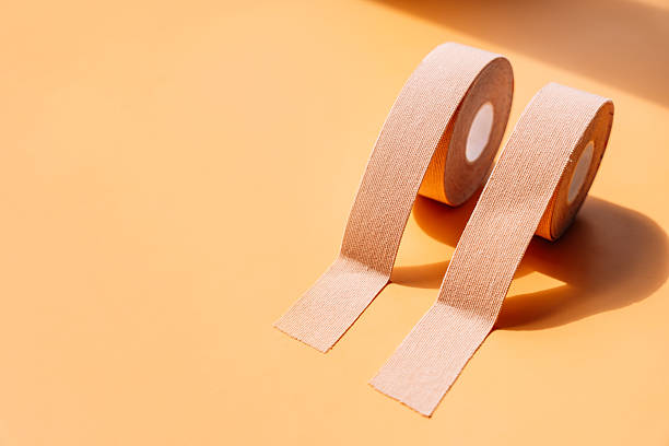 istock Adhesive tapes for the face in rolls on a yellow background, hard light 2212973820