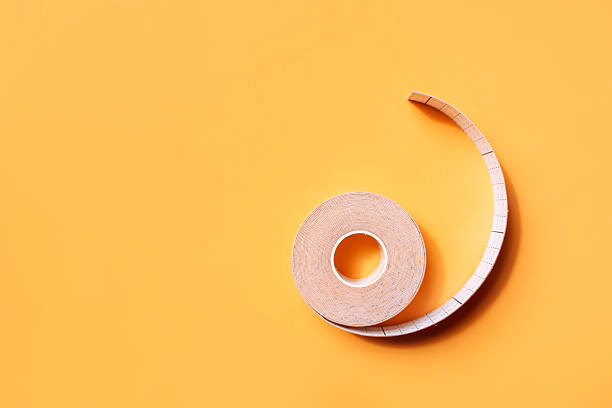 istock Adhesive tapes for the face in rolls on a yellow background 2212973823