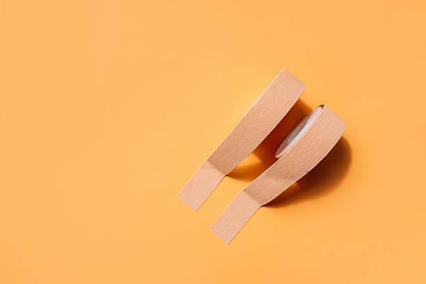 istock Adhesive tapes for the face in rolls on a yellow background 2212973834