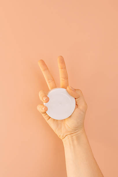 istock Hand holding a plastic jar filled with snus against a brown background 2212973914