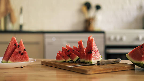 istock Triangular pieces of watermelon on a wooden cutting board on a kitchen background 2212974047