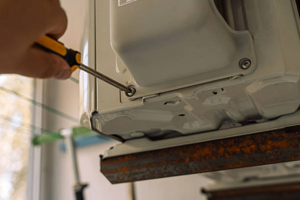 istock A man twists a screw with a screwdriver on the air conditioner casing 2212974198