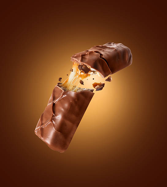 istock Chocolate bar with nuts crushed into two halves close up on a brown background 2212976122