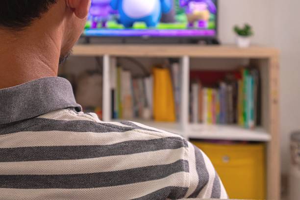 istock Asian man relaxing on sofa while watching the TV at home 2212986031