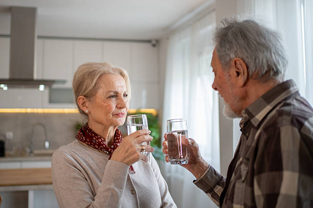 istock Senior couple drinking water together in their kitchen 2212992844
