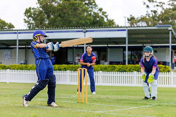 Young female cricket player playing a shot during a cricket match