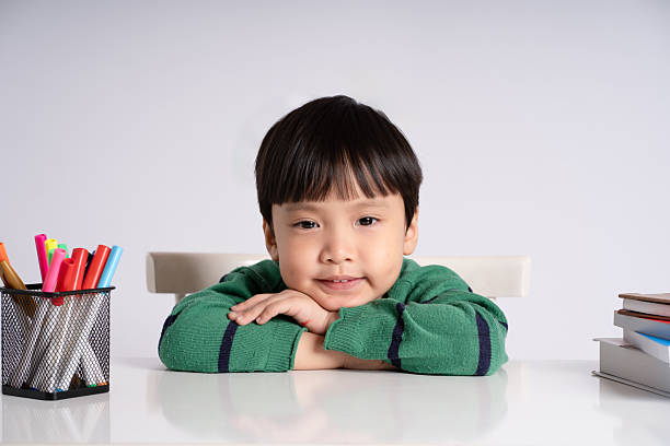 Portrait of an Asian boy studying on a white background