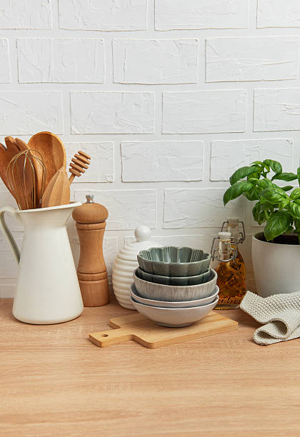 istock Kitchen utensils, bowls and spices resting on wooden countertop with white brick wall background 2212997445