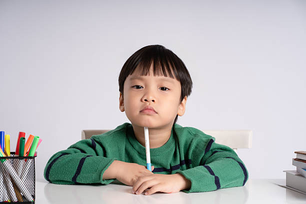 Portrait of an Asian boy studying on a white background