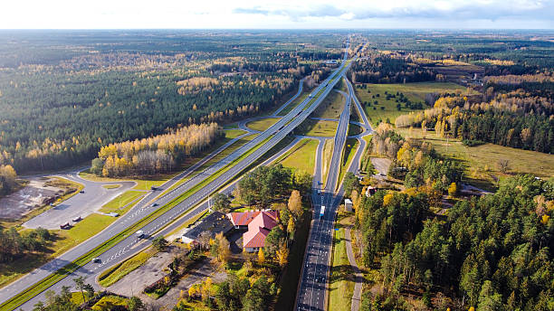 istock Drone View of Forest Highway Interchange Surrounded by Autumn Trees 2213000543