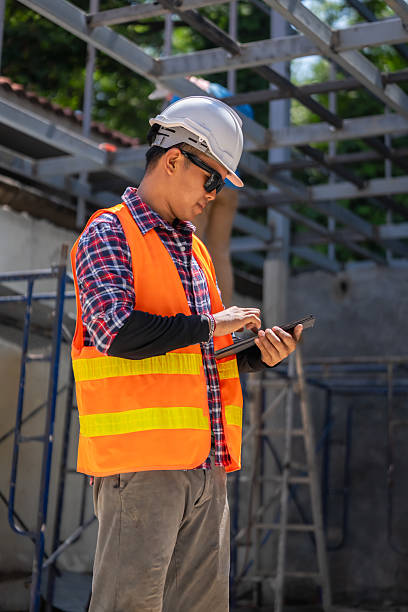 istock Male engineer uses tablet and blueprints to plan warehouse construction work 2213002180