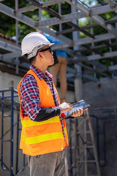 istock Male engineer uses tablet and blueprints to plan warehouse construction work 2213002186