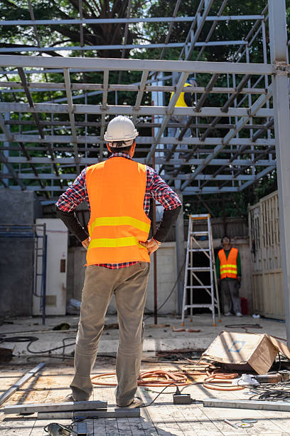 istock Male engineer uses tablet and blueprints to plan warehouse construction work 2213002216