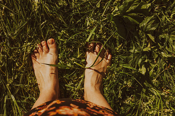 istock women's bare feet are standing on the grass 2213006006