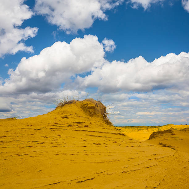 sandy desert dune undder a blue cloudy sky