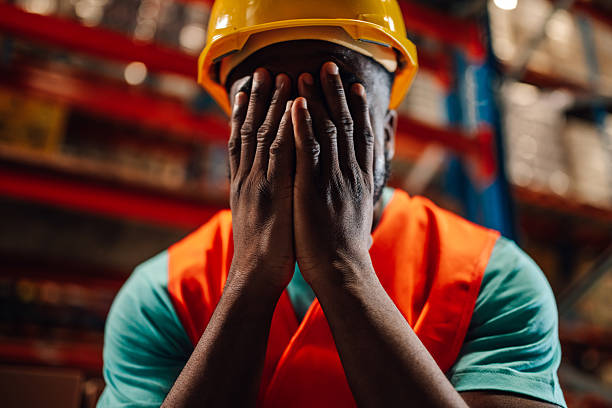 istock Stressed black warehouse worker covering face with hands 2213009457