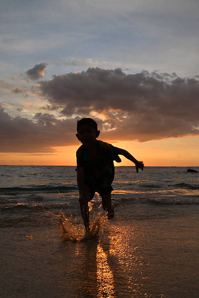 A boy Enjoying the sunset on the beach