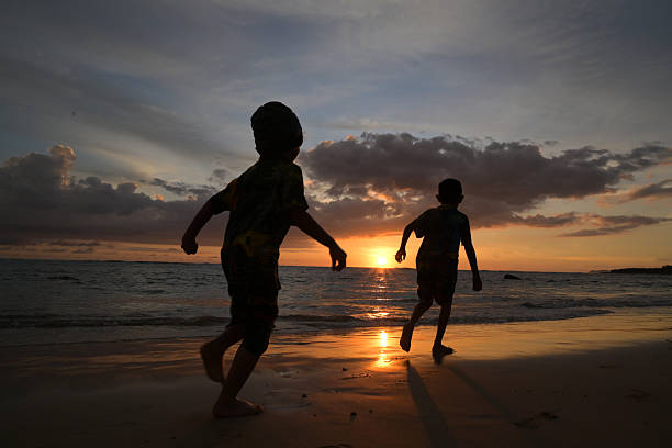 istock Children Running at Sunset on the Beach 2213013274