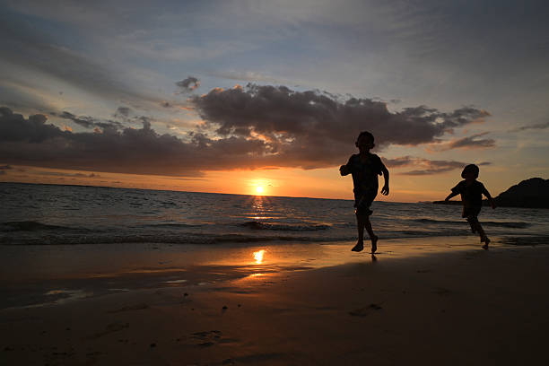 istock Children Running at Sunset on the Beach 2213013291