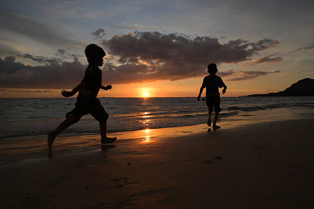 istock Children Running at Sunset on the Beach 2213013330