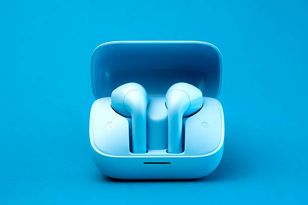 istock A pair of stylish wireless earbuds inside an open charging case, set against a vibrant blue background. Compact, portable, and modern design, ideal for music lovers and tech enthusiasts 2213013677