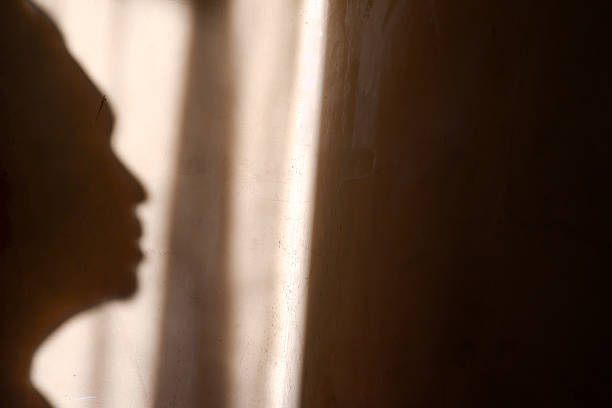 istock shadow of a person's face on the wall exposed to sunlight 2213015302