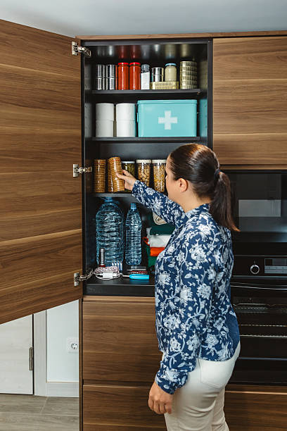 istock Unrecognizable female preparing 72 hours emergency survival kit stored in a kitchen cupboard 2213016122
