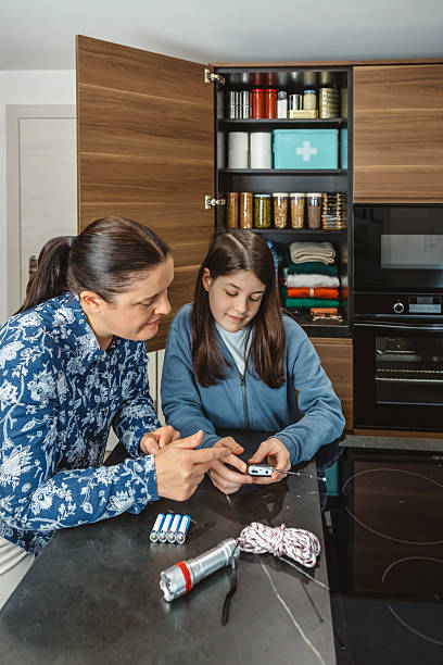 istock Smiling daughter in kitchen learning how to use analog radio during emergency or power outage 2213016137