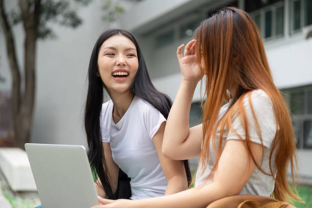 istock Two university students laughing and sharing ideas, promoting collaboration in education 2213021334