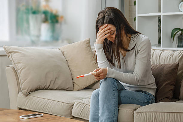 istock Sad woman looking at negative pregnancy test 2213021672