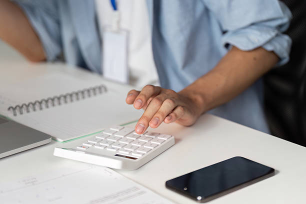 istock Close-up of a financial professional using a calculator for data analysis in an office. 2213022575