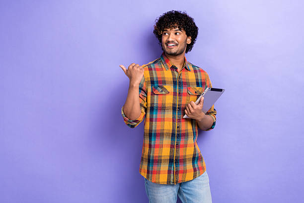 istock Photo of young man secretary data analytic hold tablet gadget pointing finger empty space presentation isolated on violet color background 2213022669
