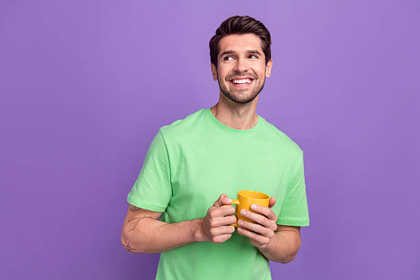 istock Photo of dreaming funny office manager guy coffee break hold cup looking empty space interested teatime isolated on purple color background 2213023813