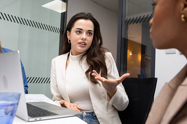 istock Young businesswomen in discussion by a laptop computer 2213024331