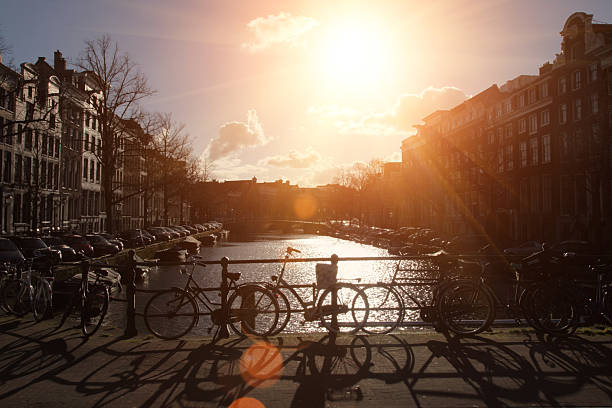 Amsterdam bridge over canal bicycles sunset sun, the Netherlands