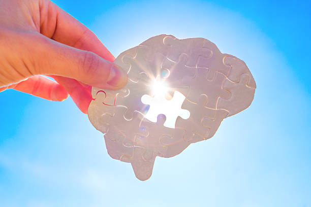 istock Illuminated Incomplete Human Brain Shaped Puzzle in Hand on Blue Sky Background 2213027810