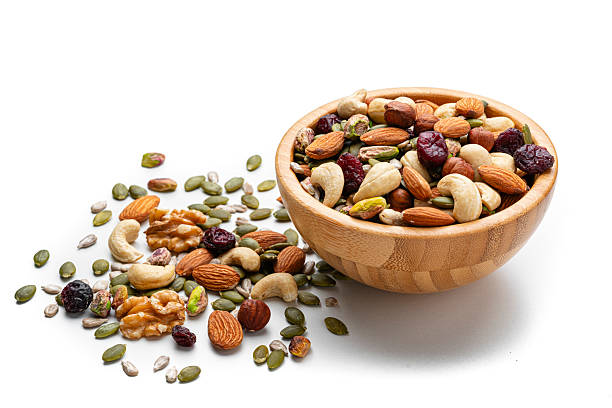 Trail mix: nuts and seeds in a bowl isolated on white background