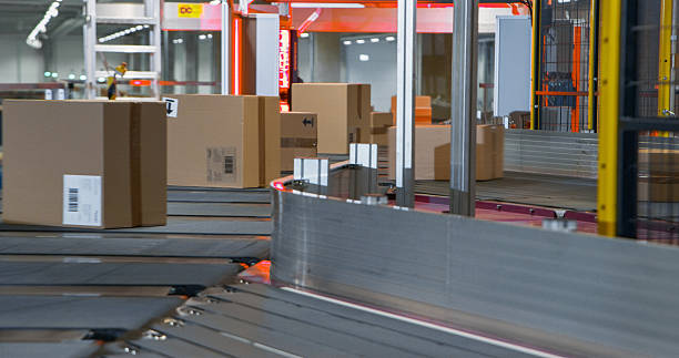 istock Cardboard Parcels, Boxes, Packages are Transported on an Automated Conveyor Line in a Busy Sorting Center at a Postal Service Warehouse. Concept of Logistics and Shipping Operations 2213036738