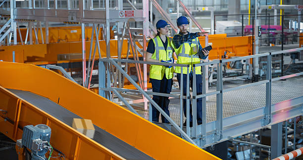 istock Young Team of Logistics Specialists Using a Tablet Computer to Oversee Parcel Sorting in a Postal Service Hub. Manager and Worker Having a Conversation while Optimizing Warehouse Productivity 2213037440