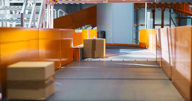 istock Cardboard Parcels, Boxes, Packages are Transported on an Automated Conveyor Line in a Busy Sorting Center at a Postal Service Warehouse. Concept of Logistics and Postal Service Operations 2213037562