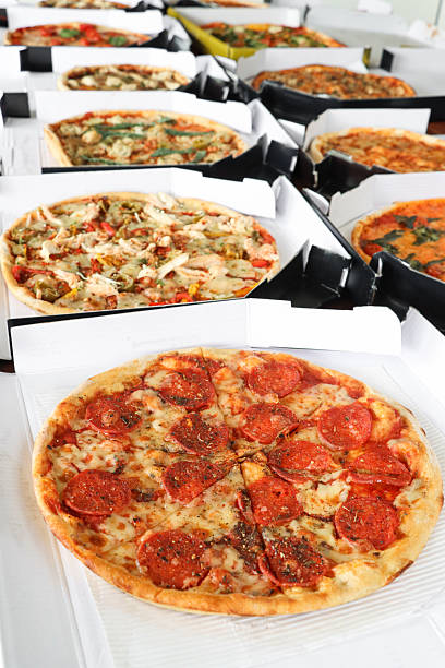 Stock photo shows a tempting mixed pizza buffet featuring a selection of pepperoni pizzas alongside other delicious options, perfect for a takeaway or party spread. This image showcases a variety of toppings, making it ideal for casual gatherings, event catering, or food delivery